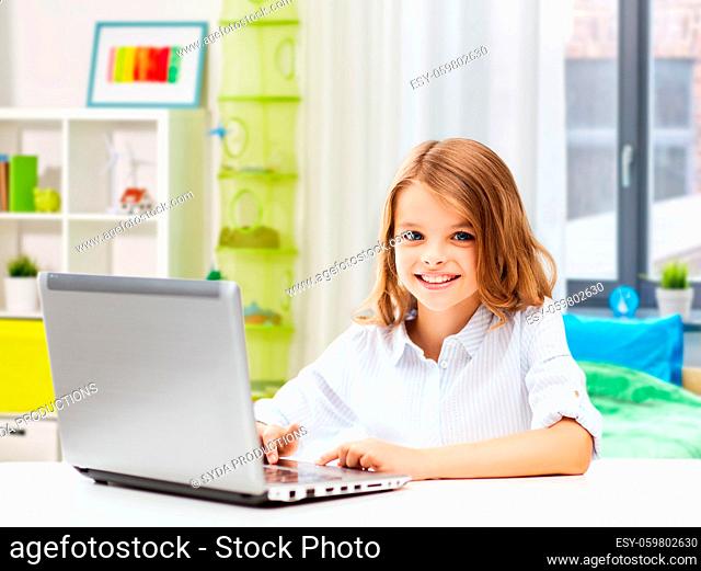 smiling student girl with laptop computer at home