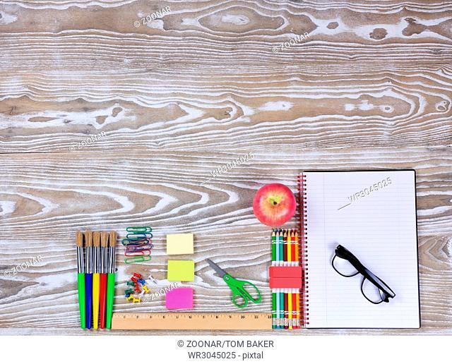 Back to school supplies on faded white wood background