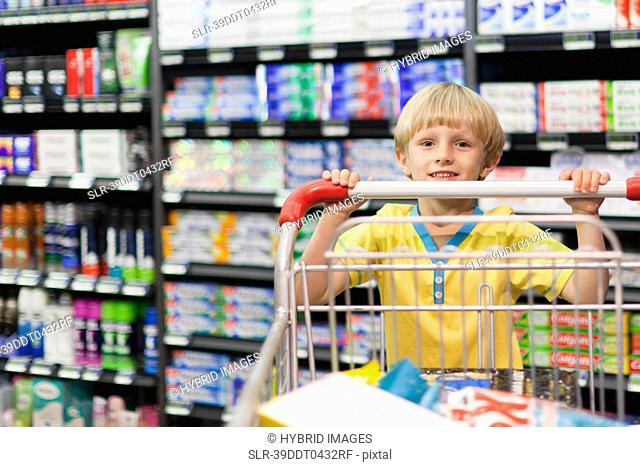 Boy pushing cart in grocery store