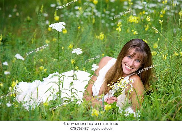 Woman with wildflower bouquet in meadow