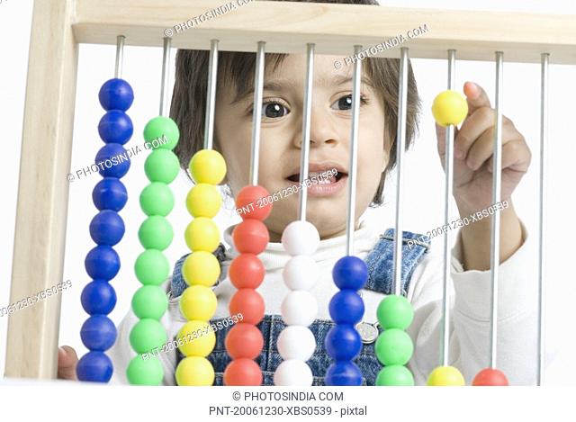 Close-up of a boy playing with an abacus