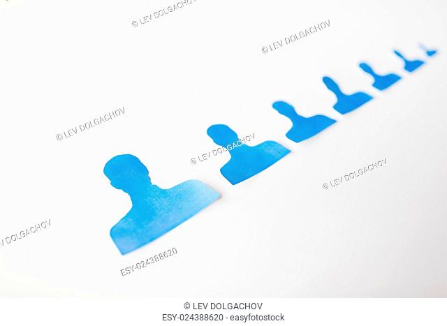 business, employment, population, career and hiring concept - close up of paper people shapes on white board