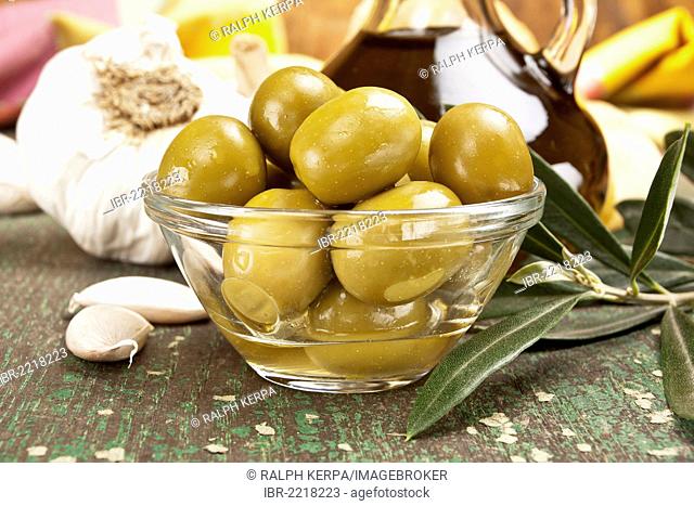 Olives with garlic and a bottle of olive oil