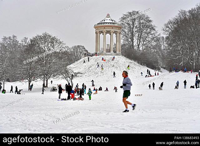 Weather picture / Winter in the English Garden in Muenchen - numerous sledge drivers and tobogganists - but also a jogger in shorts frolic in the snow on the...