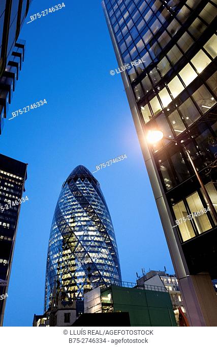 Sunset view of modern architecture building, 30 St Mary Axe, widely known informally as The Gherkin, with a lamppost in the foreground