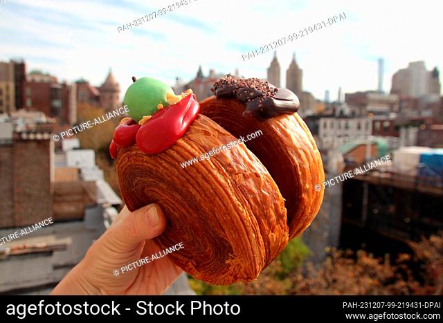17 November 2023, USA, New York: A woman holds two ""Suprêmes"" - similar to croissants, filled with apple-caramel cream (left) and chocolate cream (right)