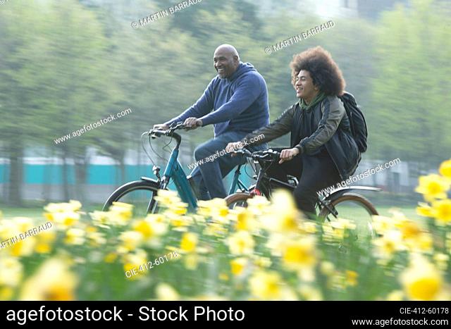 Happy father and son riding bicycles in spring park