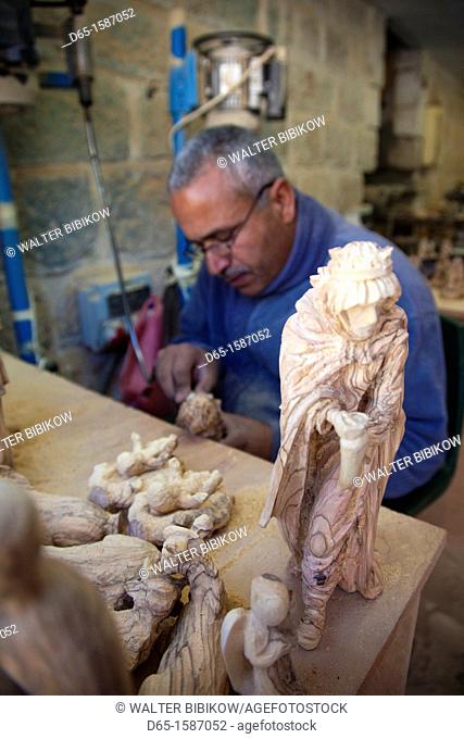 Israel, West Bank, Bethlehem, Arab Christian artisan making wooden religious figures, R, MR-ISL-11-003