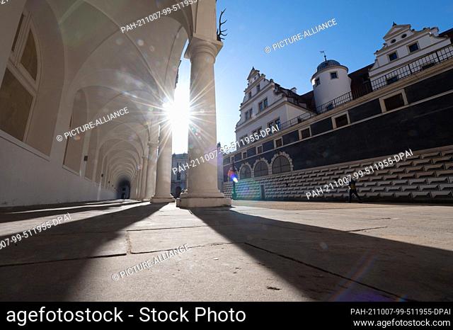 07 October 2021, Saxony, Dresden: A passer-by walks next to the Tuscan columns in the stable yard of the Residence Palace