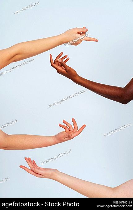 Woman gesturing toward each other against white background