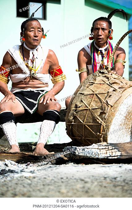 Naga tribal men in traditional outfit playing drum, Hornbill Festival, Kohima, Nagaland, India