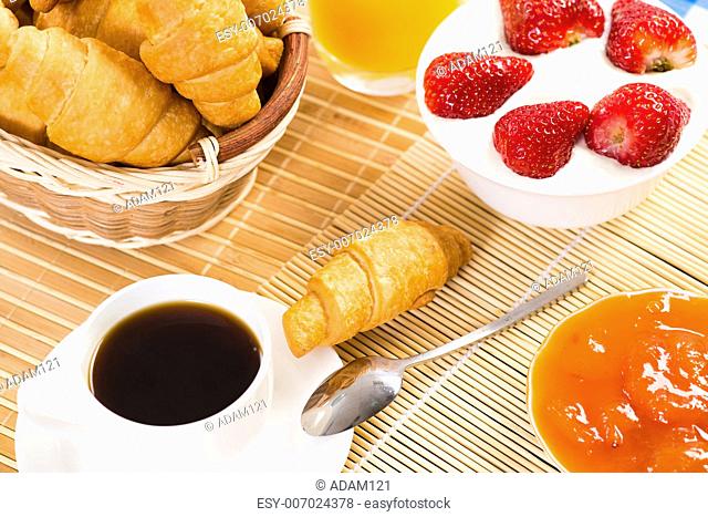 continental breakfast: coffee, strawberry with cream, croissant