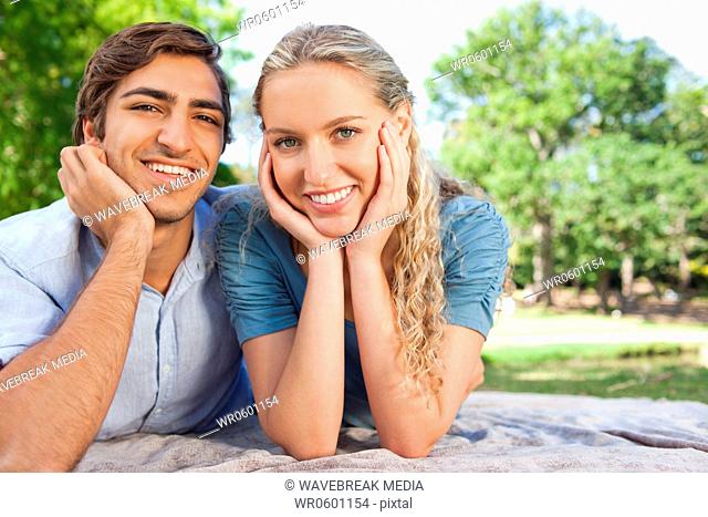 Smiling couple lying on the lawn together