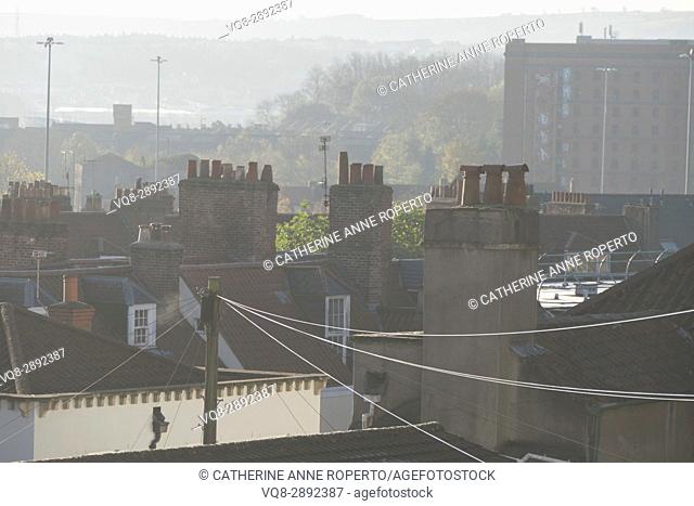 Early morning summer haze over C18th rooftops and chimney pots with tobacco factory backdrop, Hotwells, Bristol, England, UK