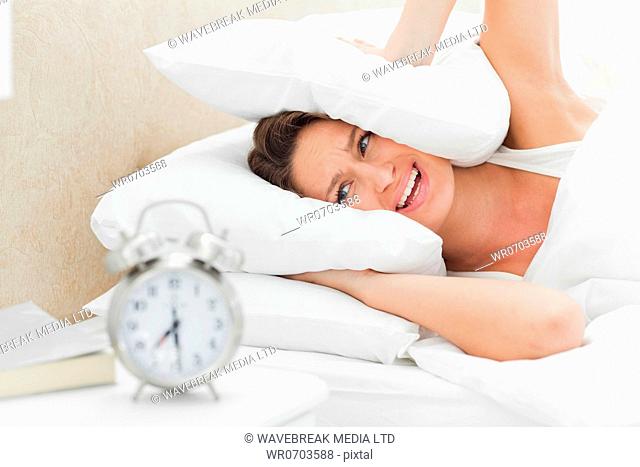 Woman crying while her alarm is ringing in foreground
