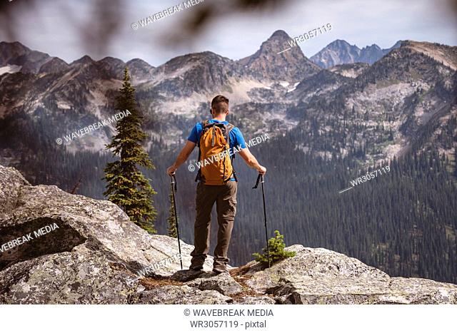Male hiker looking at solar eclipse on a rocky mountain