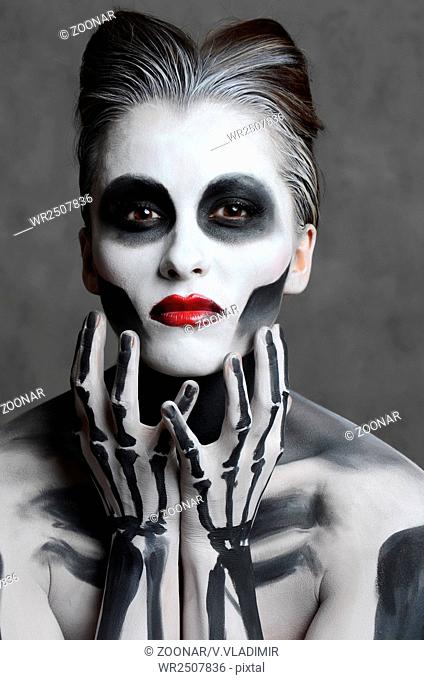 Young woman with dead mask skull face art. Halloween face