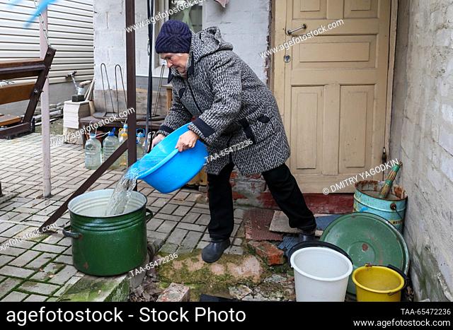 RUSSIA, DONETSK - DECEMBER 4, 2023: A woman fills a bucket with service water in Donetsk's Leninsky District. Due to problems with water supply