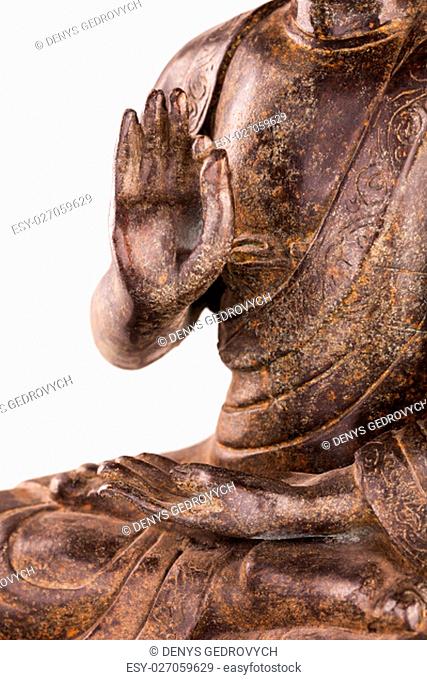 Buddha Shakyamuni's figure in a manual pose - vitarka mudra. The old statue made of metal isolated on a white background
