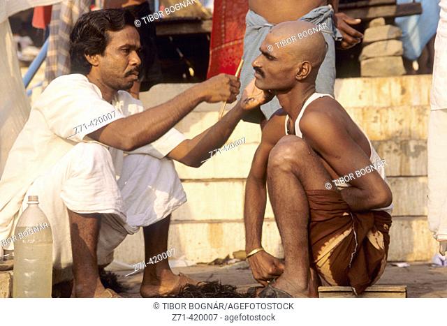 Barber on the 'Ghats' by the Ganges. Varanasi, Uttar Pradesh. India