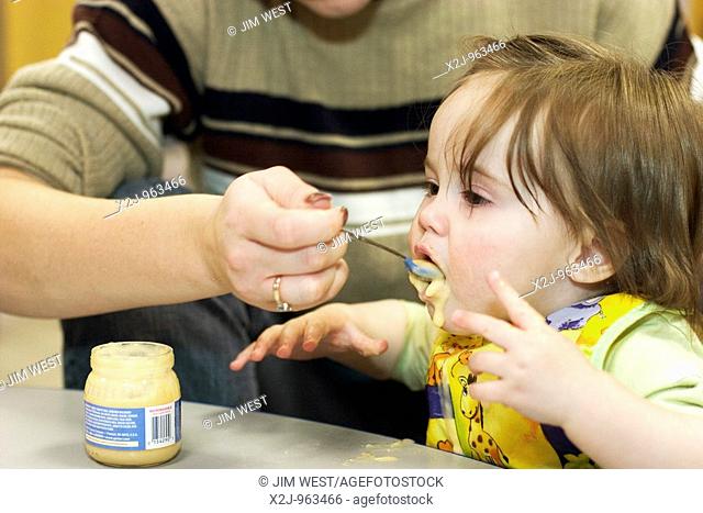Grand Rapids, Michigan - A child care worker feeds a young girl lunch in the child care center at United Methodist Community House  The Community House serves...