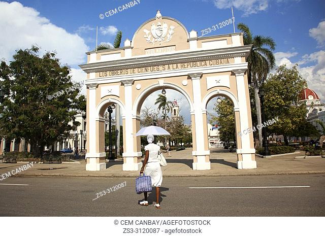 Cuban woman wearing white dress in front of the Arch Of Triumph-Arco Del Triunfo at Parque Jose Marti in Plaza de Armas Square, Cienfuegos, Cuba, West Indies