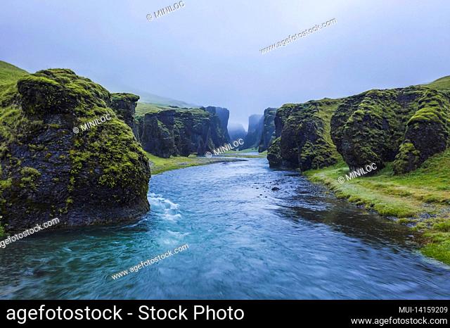 the famous and unique fjadrargljufur valley in iceland on a rainy day. mossy cliffs and mountain river. point of interest for tourists coming to visit iceland