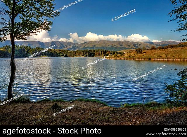 Stunning nature composition. Day view over the lake and mountain. Lake reflected the clouds