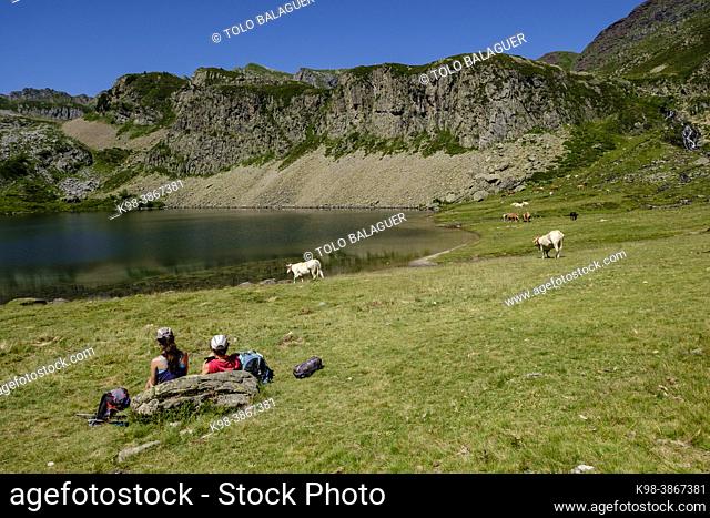 hikers resting on Lac du Miey, Ayous lakes tour, Pyrenees National Park, Pyrenees Atlantiques, France