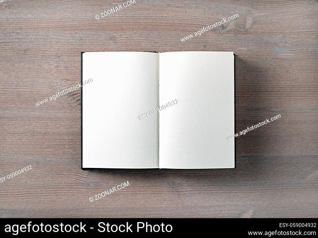 Opened blank book mock up on wood table background. Flat lay