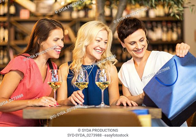 women with shopping bag at wine bar or restaurant
