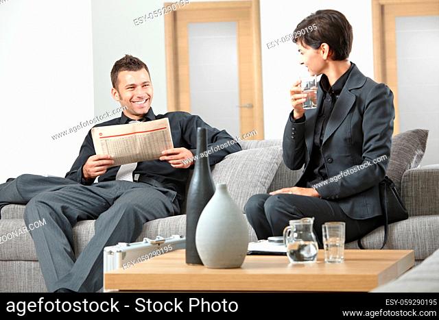 Business people sitting on sofa at office anteroom waiting and talking