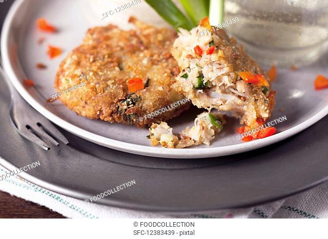 Partially eaten small crab cakes with red pepper