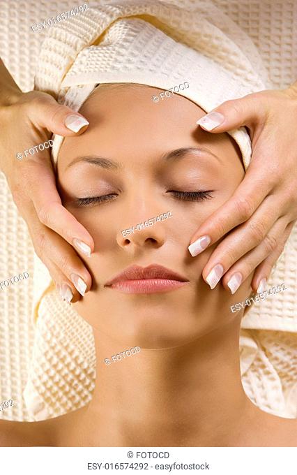 nice close up on face of young beautiful woman getting an hands massage