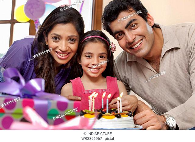 Girl celebrating her birthday with parents