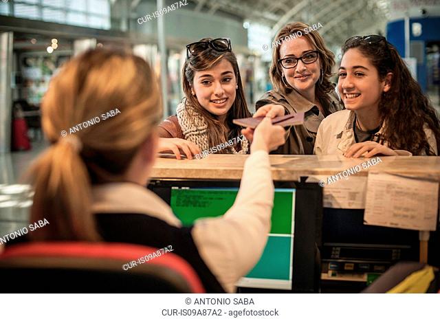 Woman and two teenage girls at airport check in area