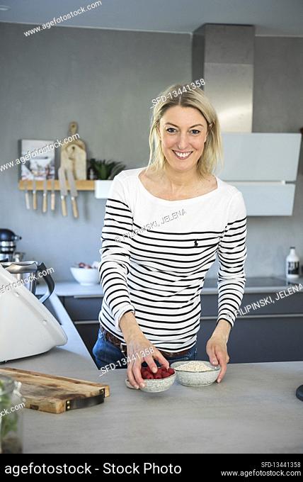 Blonde woman with a breakfast bowl in a kitchen