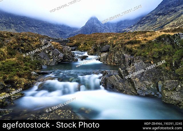 The dramatic Cuillin Mountains surround a section of the fairy pools, a tributory of the Brittle River. On a sunny day, the pools take on a luminous blue hue