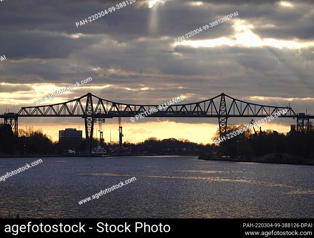 04 March 2022, Schleswig-Holstein, Osterrönfeld: The Rendsburg high bridge with the floating ferry across the Kiel Canal (NOK) connects Osterrönfeld (l) and...
