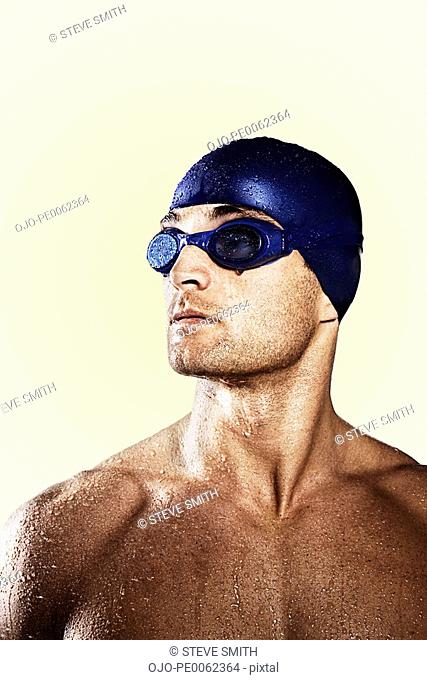 Wet swimmer wearing cap and goggles