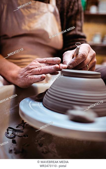 Midsection of craftsman making ceramic container