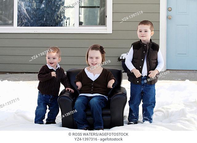 Two brothers and a sister outdoors in the snow