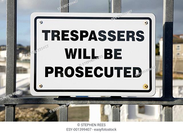 Trespassers will be prosecuted sign on a metal fence