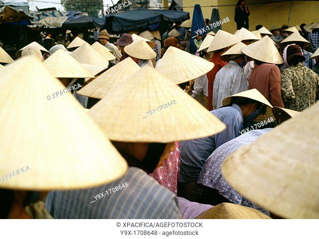 Crowds of people wearing conical bamboo hats at a wet market for fresh fish in Vietnam The people come to buy and sell freshly caught fish from the sea
