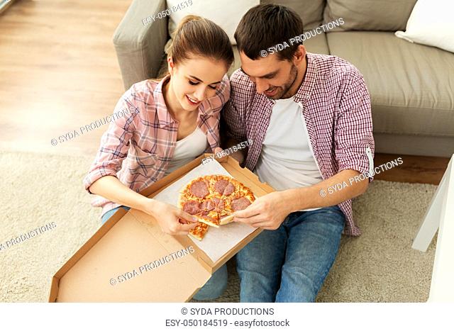 couple eating takeaway pizza at home