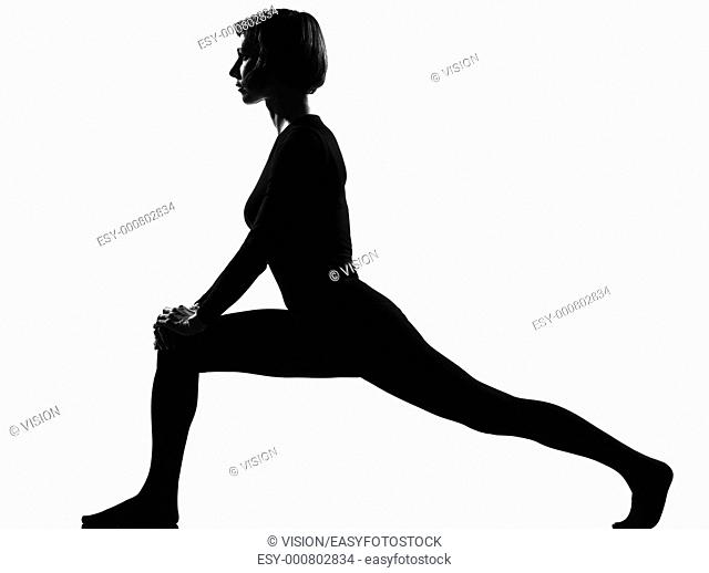woman exercising fitness yoga stretching in shadow grayscale silhouette full length in studio isolated white background