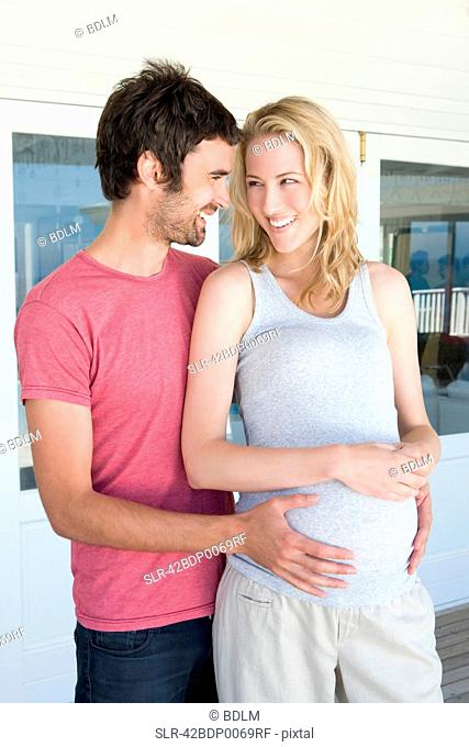 Man holding pregnant girlfriends belly