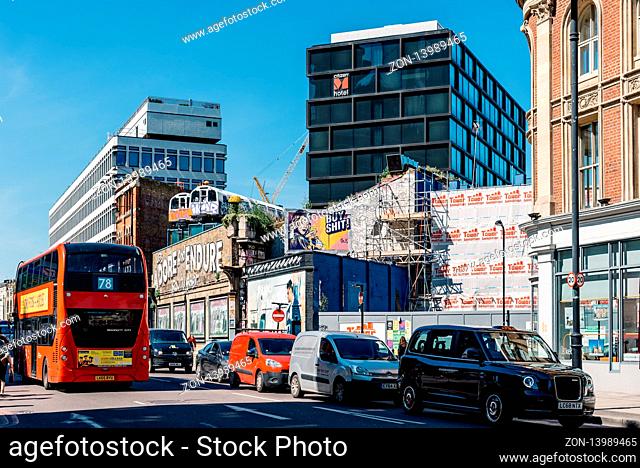 London, UK - May 14, 2019: Train carriages on top of old building and new office buildings in Shoreditch