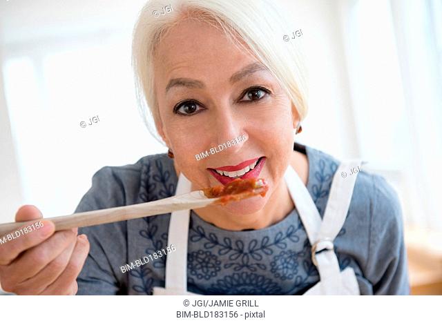 Caucasian woman tasting sauce