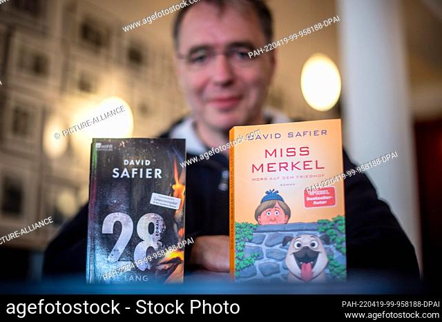 11 April 2022, Bremen: David Safier, author, with two of his books, recorded at an interview appointment. With his two novels about the investigative former...